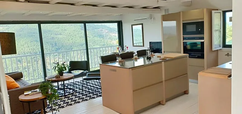Open-plan living and kitchen area with island and floor-to-ceiling windows over the valley, Casa da Viña